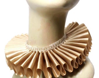 May include: A beige ruffled collar with a white lace trim. The collar is made of satin and is designed to be worn around the neck.