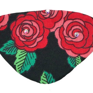 May include: Black eye patch with red roses and green leaves. The eye patch has two rhinestones.