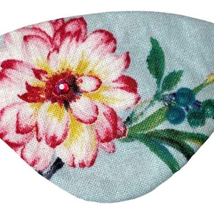 Può includere: Fascia per occhi floreale con sfondo azzurro. Presenta un grande fiore con petali rossi e rosa, un centro giallo e una piccola gemma rossa. Sono presenti anche foglie verdi e bacche blu. È attaccata una fascia elastica nera.