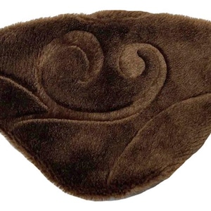 Könnte beinhalten: Eine braune Augenmaske mit weicher, plüschiger Textur. Die Maske hat ein geprägtes Wirbeldesign und ein elastisches Band für einen sicheren Sitz. Diese Schlafmaske ist so konzipiert, dass sie Licht blockiert.