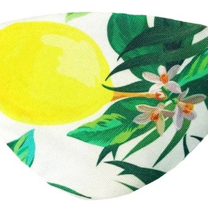May include: A white eye patch with a lemon and tropical leaf design. The lemon is yellow and the leaves are green.