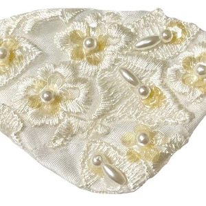 May include: Ivory-colored headband featuring a floral lace design. The lace is adorned with small, round pearls and elongated pearl accents. The headband has an elastic band for a comfortable fit. The floral pattern is in a soft yellow hue.