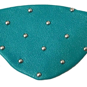 May include: A teal leather eye patch with silver studs.