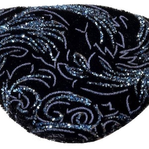May include: A black eye patch featuring a textured velvet surface with a shimmering blue glitter floral pattern. The eye patch is shaped to cover one eye and includes a thin black elastic strap attached to the sides for secure placement.