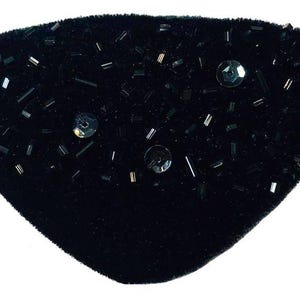 May include: A black velvet eye patch with black sequins and beads.