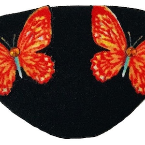 Könnte beinhalten: Schwarze Augenmaske mit zwei orangefarbenen und gelben Schmetterlingen mit Strasssteinen auf jedem Flügel.