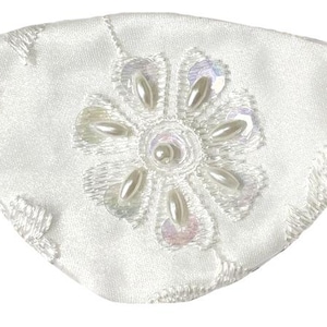 Pode incluir: Um tapa-olho de cetim branco com um motivo floral bordado ao centro, acentuado com pérolas artificiais brancas e lantejoulas iridescentes. O tapa-olho inclui uma tira elástica bege fixada em ambos os lados para fixação.