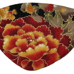 Könnte beinhalten: Ein fächerförmiges Accessoire mit floralem Design. Der Stoff zeigt eine große rote und gelbe Pfingstrose mit goldenen Akzenten auf schwarzem Hintergrund. Ein schwarzes Gummiband ist angebracht.