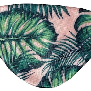 Könnte beinhalten: Eine rosa Augenmaske mit einem tropischen Blättermuster in Grüntönen. Die Maske hat ein schwarzes Gummiband für einen sicheren Sitz. Das Design zeigt große, detaillierte Blätter.