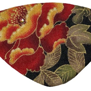 Könnte beinhalten: Eine Augenklappe mit einem lebendigen Blumenmuster aus großen roten und gelben pfingstrosenartigen Blüten auf schwarzem Grund. Der Stoff hat einen dezenten metallischen Goldglanz in den Blättern und Blütenblättern sowie eine kleine Perle.
