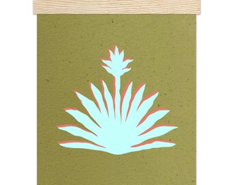 May include: A wall hanging featuring a light blue agave plant illustration with coral red accents on a textured olive green background, held by two light wood horizontal rails with a thin black string attached to the top rail for hanging.