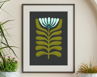 May include: A framed wall art print featuring a stylized botanical illustration on a dark gray background. The artwork depicts a central plant with olive green symmetrical leaves and a single light blue flower at the top with a dark teal center.