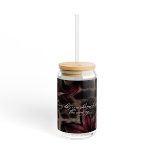 May include: A clear glass tumbler with a bamboo lid and a clear glass straw. The exterior features a dark leopard print pattern accented with deep burgundy floral elements and the white cursive text: Every day is a chance to rewrite the ending.
