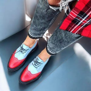 K&ouml;nnte beinhalten: Zweifarbige Oxford-Schuhe in Hellblau und Rot. Die Schuhe haben schwarze Schn&uuml;rsenkel und Sohlen. Das Design wird durch eine Jeans mit Used-Look erg&auml;nzt. Stilvolle Schuhe.