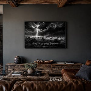 May include: A rectangular wall art print in a black frame featuring a dramatic black and white landscape of a lightning storm over a desert. The text reads: The voice of the Lord strikes with flashes of lightning. The voice of the Lord shakes the desert. Psalm 29:7-8.