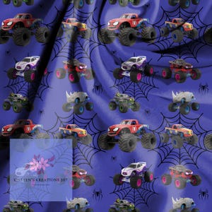 May include: A repeating pattern of toy monster trucks in various colors, including red, blue, and black, on a purple background with black spiderwebs. The image includes the text "Kirsten's Kreations 207".