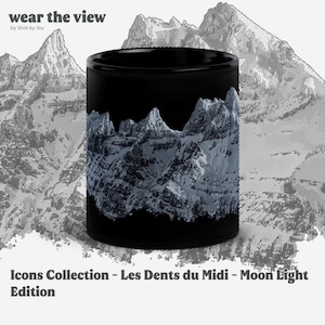 May include: Black ceramic mug featuring a mountain range design in shades of gray and white. The mug has the text "wear the view" and "Icons Collection - Les Dents du Midi - Moon Light Edition".