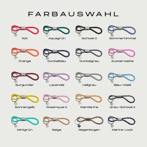 Puede incluir: Una selecci&oacute;n de llaveros en varios colores, incluyendo rojo, verde, negro y azul. Cada llavero presenta un dise&ntilde;o de bucle con un cierre de metal y un peque&ntilde;o dije. El texto "FARBAUSWAHL" est&aacute; en la parte superior.
