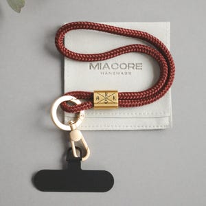 Könnte beinhalten: Ein Set aus drei Keramikbechern mit gesprenkelter, matter Oberfläche. Die Becher sind in Creme-, Hellgrau- und Dunkelgrautönen gehalten. Jeder Becher hat ein schlichtes, minimalistisches Design, ideal für Kaffee oder Tee.