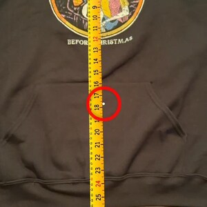 Puede incluir: Sudadera con capucha negra con un gr&aacute;fico de "Pesadilla antes de Navidad", con Jack Skellington y Sally. La sudadera tiene un bolsillo delantero y un cord&oacute;n multicolor. La longitud total es de aproximadamente 46 cm.