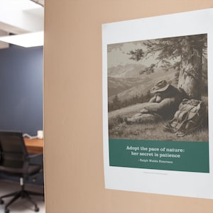 May include: A framed print featuring a sepia-toned illustration of a person resting under a tree, with a backpack nearby. The print includes the quote "Adopt the pace of nature: her secret is patience" by Ralph Waldo Emerson.
