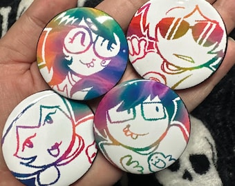 May include: Four round white buttons with cartoon character designs. Each button features a different character outline in rainbow colors against a white background. The characters have various expressions and wear glasses or sunglasses.
