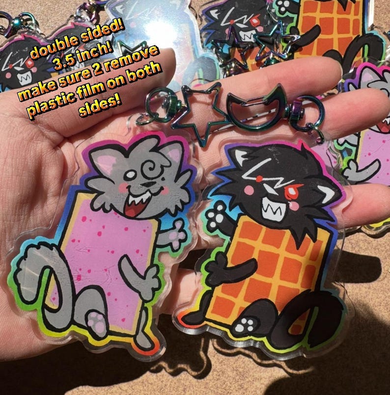 May include: Double-sided acrylic keychains featuring cartoon cat characters holding food items. The keychains are 3.5 inches in size and have a protective plastic film. The text on the image says "double sided! 3.5 inch! make sure 2 remove plastic film on both sides!"