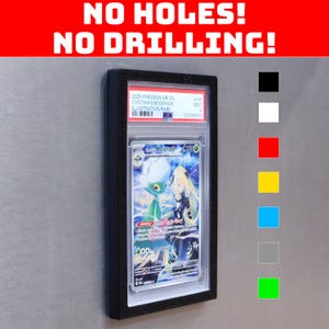 May include: A black magnetic card holder displaying a Pokemon card with the text "NO HOLES! NO DRILLING!". The card features a Roserade illustration. The holder has a clear front and a black frame, with color swatches on the right.
