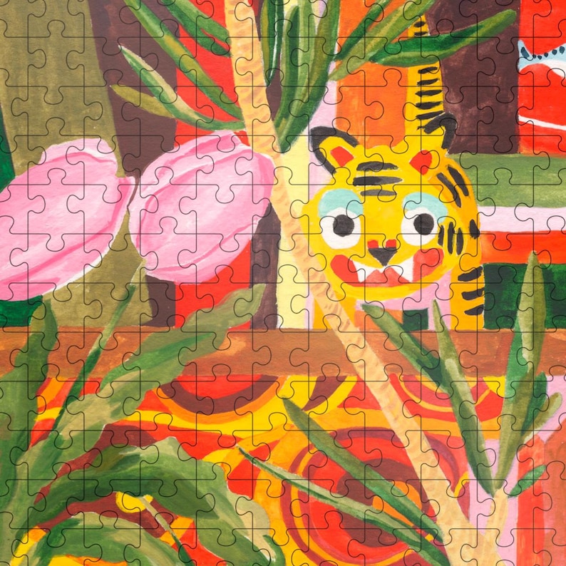 May include: A colorful jigsaw puzzle featuring a whimsical illustration of a yellow tiger peeking through green foliage and pink flowers. The puzzle has a jungle theme with a vibrant, artistic design.