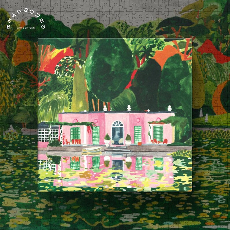 May include: A completed jigsaw puzzle featuring a pink building with green shutters and a reflection in the water. The puzzle has a colorful illustration of a garden scene with trees and a pond. The puzzle is surrounded by a gray puzzle border with the text "BEAUBOURG ART EDITIONS".