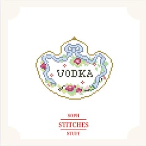 May include: A cross-stitch design with the word "VODKA" in black, framed by a floral and ribbon border in blue, pink, and green. The design is on a white background, with the text "SOPH STITCHES STUFF" below, in a decorative style.