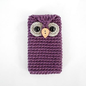 May include: Purple crocheted owl phone case with grey felt eyes and a wooden beak.