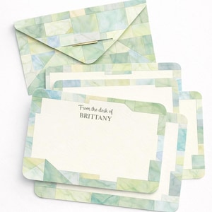 Op de afbeelding: Briefpapier set met een envelop en notitiekaarten. De envelop en kaartranden hebben een geometrisch patroon in groen- en blauwtinten. De notitiekaarten hebben de tekst "From the desk of BRITTANY".
