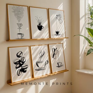 May include: Six framed art prints with coffee-themed illustrations in black and white. The prints depict coffee beans, cups, and brewing equipment. The text "MEMONTE PRINTS" is at the bottom of the bottom shelf.