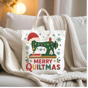 Peut inclure: Sac fourre-tout blanc avec un motif festif représentant une machine à coudre verte ornée d'un bonnet de Père Noël, de guirlandes lumineuses et de flocons de neige. Le texte "MERRY QUILTMAS" est en rouge et vert.
