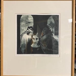 May include: A framed black and white print featuring a group of figures in a dark, shadowy setting. The artwork has a somber tone, with visible brushstrokes and textures. The frame is a light brown wood.