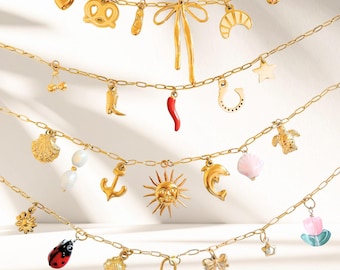 May include: Gold-toned charm necklaces with various pendants, including a heart, pretzel, bow, croissant, star, cherry, boot, chili pepper, horseshoe, seashell, anchor, sun, dolphin, and ladybug. The charms are suspended from delicate chain links.