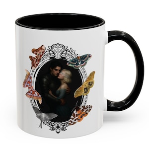 May include: White ceramic mug with a black interior and handle. The mug features a romantic illustration of a couple embracing within an ornate frame, surrounded by colourful butterfly illustrations. A unique gift for any occasion.