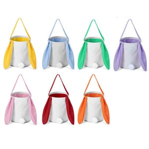 Puede incluir: Siete cestas de tela con temática de Pascua en varios colores. Cada cesta es blanca con un interior de color y orejas de conejo. Las orejas son amarillas, azules, verdes, moradas, rosas, rojas y naranjas. Una cola de pompón blanca está adjunta.