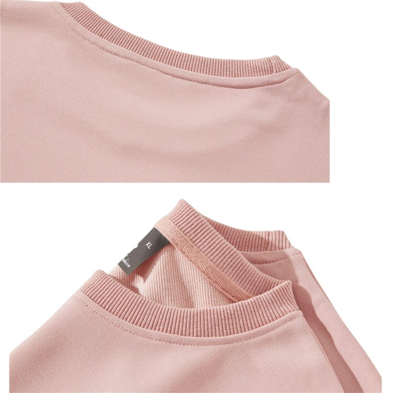 May include: Close-up of a light pink crew neck sweatshirt. The neckline and cuffs are ribbed. The tag is visible, with the size XL. The fabric appears soft and comfortable.