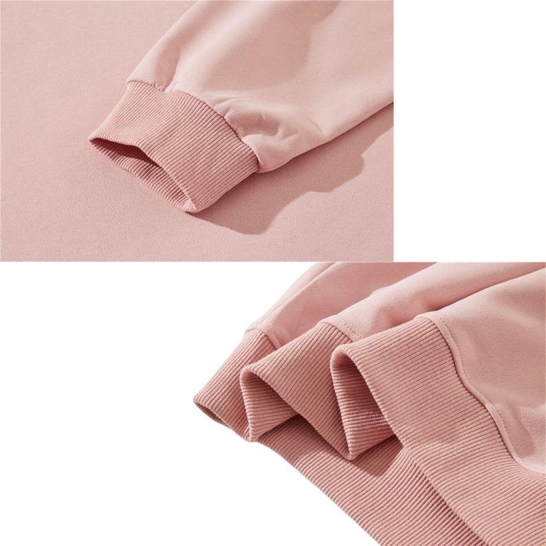 May include: Close-up of a light pink sweatshirt sleeve. The sleeve features a ribbed cuff in a slightly darker shade of pink. The fabric appears soft and comfortable, with a subtle texture.
