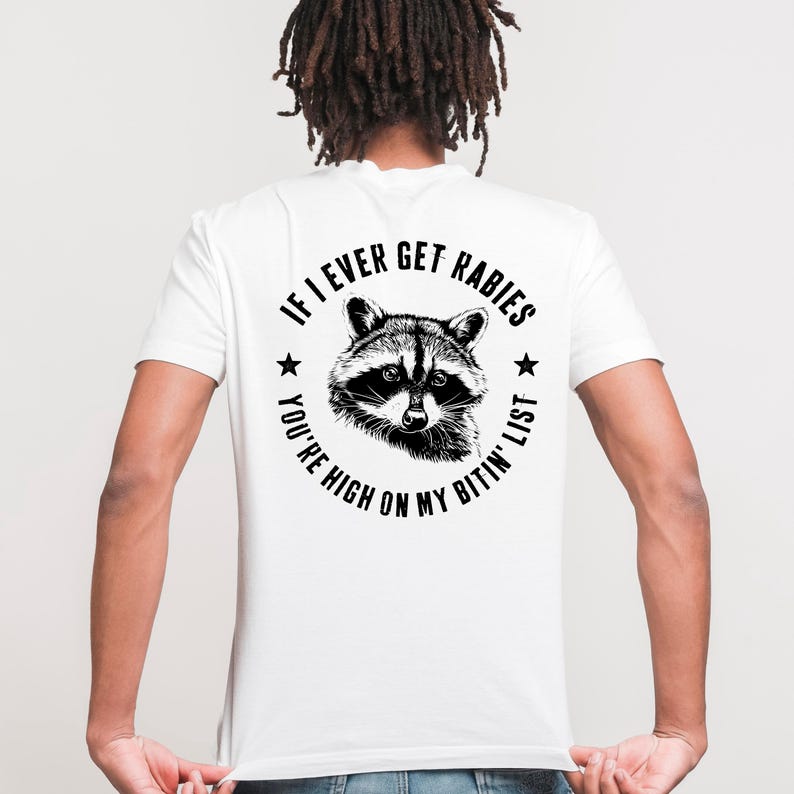 May include: White t-shirt with a black and white raccoon graphic. The text around the raccoon reads "If I Ever Get Rabies, You're High On My Bitin' List."