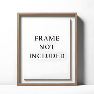 May include: A rectangular wooden frame with a white interior. The text "FRAME NOT INCLUDED" is centered on the white background in a bold, black font. The frame has a natural wood grain finish.