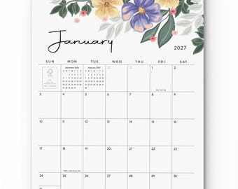 Könnte beinhalten: Ein Wandkalender für Januar 2027 mit einer floralen Illustration aus violetten und gelben Blüten sowie grünen Blättern. Das Kalendarium zeigt die Wochentage, Daten sowie kleine Referenzkalender für Dezember 2026 und Februar 2027.