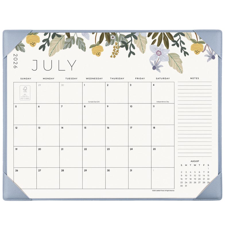 K&ouml;nnte beinhalten: Ein Schreibtischkalender f&uuml;r Juli 2026 mit hellblauem Rand und Eckschonern. Oben befindet sich eine florale Illustration mit gelben und violetten Blumen. Das Raster enth&auml;lt Wochentage, einen Notizbereich und eine kleine Monats&uuml;bersicht f&uuml;r August.