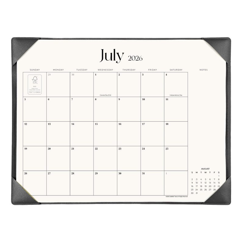 May include: A desk calendar for July 2026 featuring a white grid layout with black text, including a notes section and a small August 2026 calendar preview. The calendar is held in place by dark gray corner protectors on a rectangular frame.