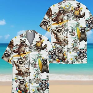 Puede incluir: Camisa hawaiana blanca con un estampado repetido de mapaches de dibujos animados en una playa. Los mapaches se representan surfeando, relajándose en sillas y usando gafas de sol. La camisa tiene una parte delantera abotonada y mangas cortas, con un fondo tropical de flores y palmeras.