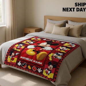 May include: A rectangular fleece blanket featuring a red background with multiple illustrations of Mickey Mouse in various poses. The centre displays a large Mickey Mouse graphic with the name MICHELLE MANN printed in white capital letters.