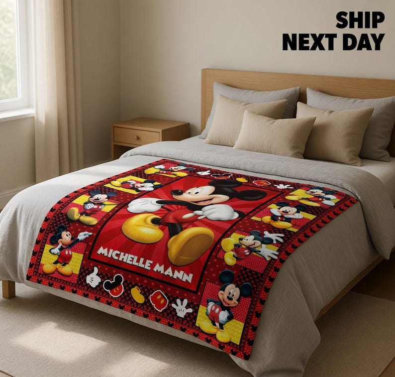 May include: A rectangular fleece blanket featuring a red background with multiple illustrations of Mickey Mouse in various poses. The centre displays a large Mickey Mouse graphic with the name MICHELLE MANN printed in white capital letters.