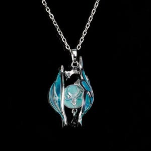 Op de afbeelding: Een zilverkleurige hangerketting met een blauw en turquoise ontwerp. De hanger heeft een centrale turquoise bol in een zilveren frame met blauwe accenten, hangend aan een delicate ketting.
